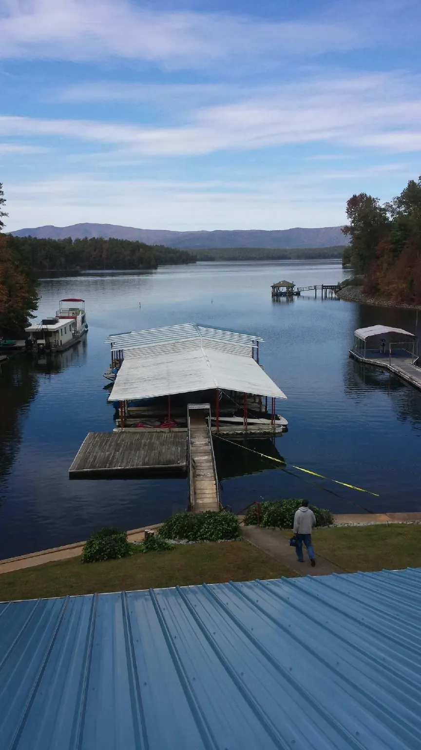 View across a lake from a newly installed blue metal roof in Monroe